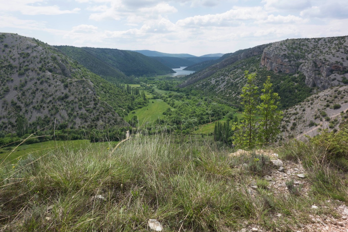 Genau da unten, wo der Weg sich an den Berg hinschnuggelt, ist die Brücke.